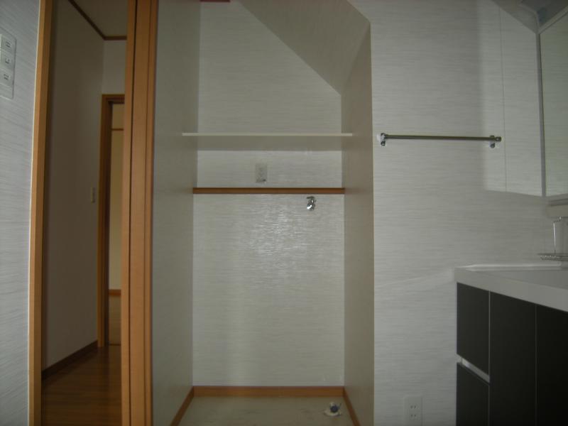 洗面化粧台横に階段スペースを利用した洗濯機置き場です。